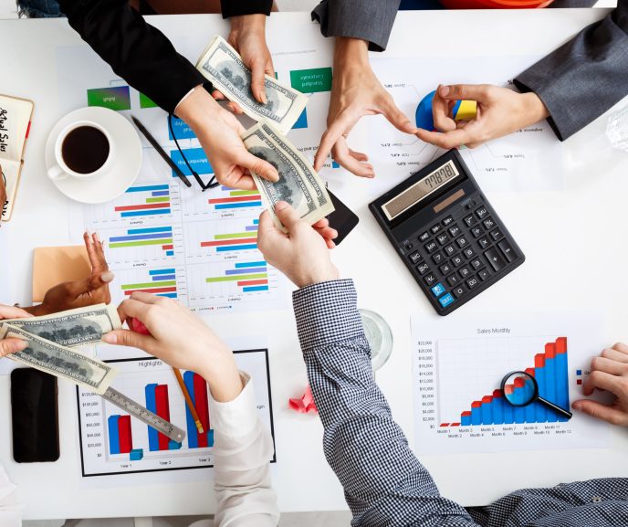 Picture of businessmen's hands on white table with documents, coffee and drafts